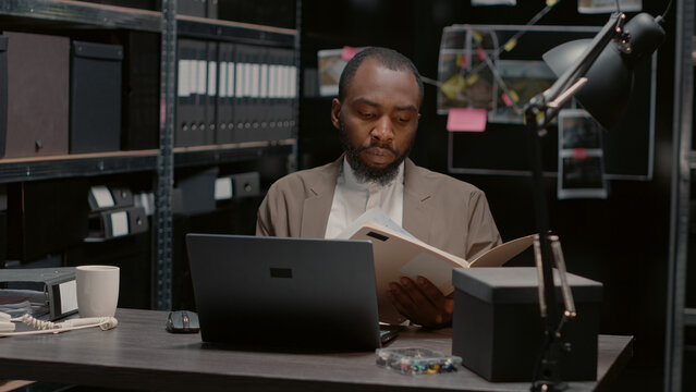 Professional inspector studying crime scene clues, examining surveillance photos to find suspect. Law enforcement officer conducting private investigation with records and evidence.