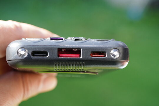 Person showing charger with flashlight LED lights with USB outputs