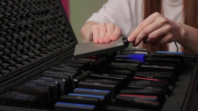 Precise sorting of multiple external storage devices in orderly rows. Systematic placement of various external hard discs emphasizing organization and cataloging principles