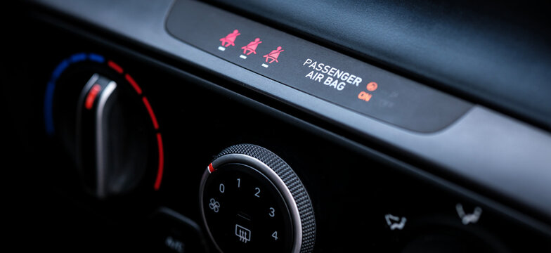 Close up view focusing on the rotary analog climate control temperature knobs and air conditioning dials located on the center console of a modern interior