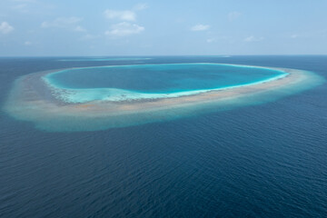 Obraz premium High aerial view of circular Maldives atoll lagoon and surrounding coral reef