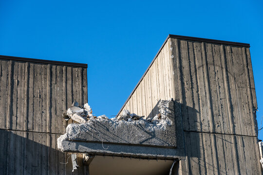 Old office building being torn down for urban redevelopment, concrete elevator columns remaining to demolish, commercial construction project job site
