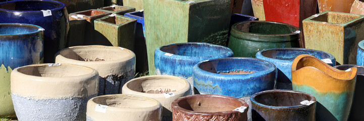 Fototapeta premium Clay ceramic pots, pottery. Gardening, landscaping. Sale at market. Multicolored, colorful, texture, shapes, forms, patterns, backgrounds