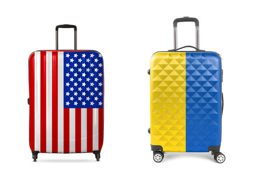 Suitcases painted in flags of USA and Ukraine isolated on white