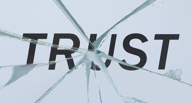 Shards of broken mirror with word Trust on white background, top view. Betrayal