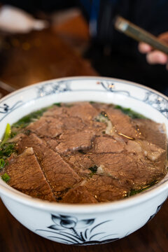 generous bowl of traditional Vietnamese Beef Pho served in a blue-and-white patterned ceramic bowl
