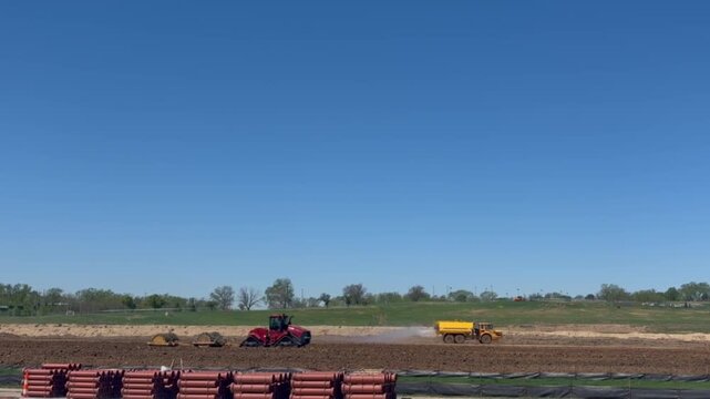 Omaha, NE, USA April 24, 2026: Construction equipment and a water truck operating at an active development site being prepared for new synthetic‑turf multi‑purpose sports fields for soccer baseball