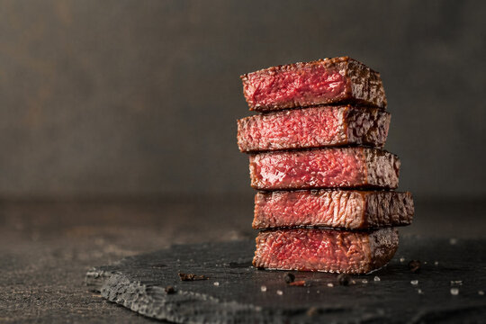 AI generated stacked slices of juicy medium rare steak with rich texture on dark surface gourmet food concept protein meal culinary detail appetizing meat