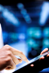 Adept engineer writing data center disaster contingency plan on tablet to provide rapid restoration of service, limit disruption and minimize interruptions to normal operations