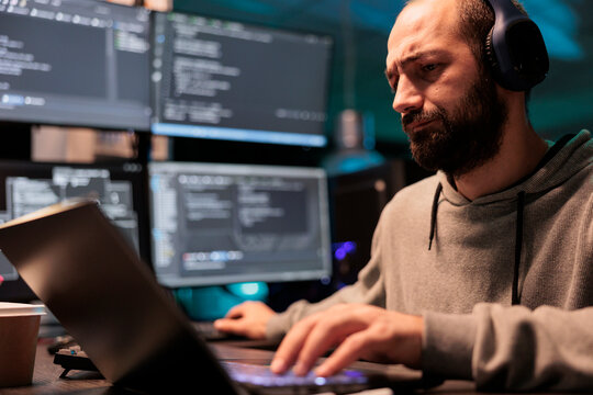 Software developer programming user interface on computer and compiling source code with html script and algorithms. Coding cloud computing online program on multiple screens at night.