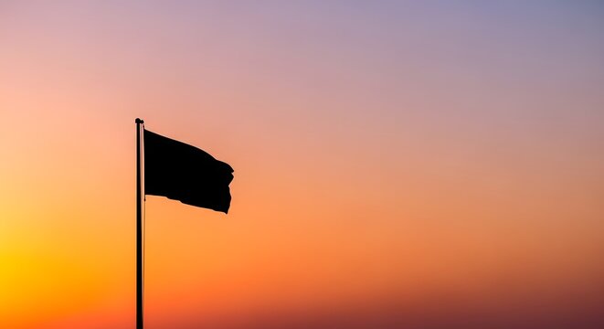 A solitary black flag waving gently against a stunning sunset backdrop, representing a moment of somber reflection or declaration