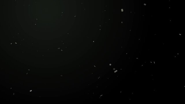 Fine dust particles float and shimmer in a bright sunbeam against a dark background