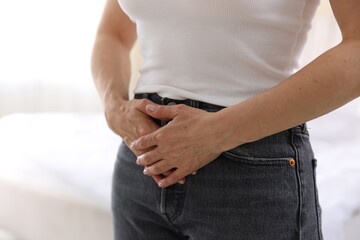 Obraz premium Menopause. Woman suffering from abdominal pain at home, closeup