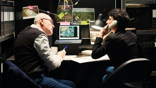 Detectives team rushing to catch culprit after receiving call with suspects whereabouts, landline phone. Police experts finding about illegal operation location, solving case. Handheld shot.