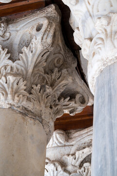 View of the intricate marble column capitals with detailed acanthus leaf carvings at the Al-Azhar Mosque in Cairo, Egypt.