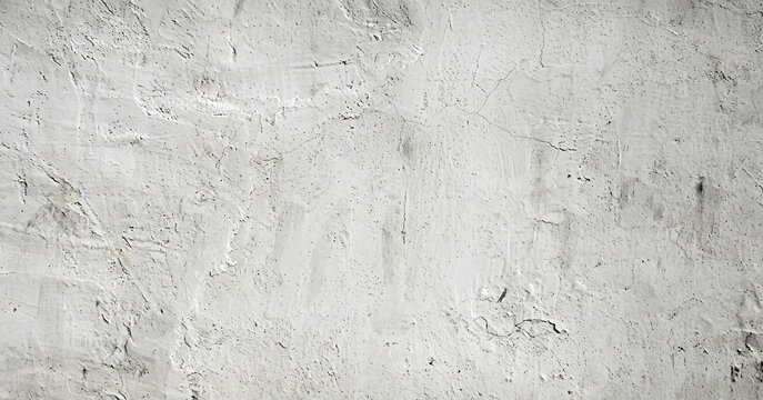 A textured concrete wall surface with a light gray color, featuring subtle imperfections and variations that add character to the image.