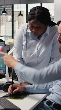 Vertical Video Team editing photos, retouching software on pc, for color grading, image selection for commercial materials, post production and catalog results. Commercial advertising agency content.