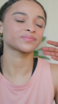 Vertical video: Speaking woman in pink at home, turning to offstage hand tapping shoulder, plant