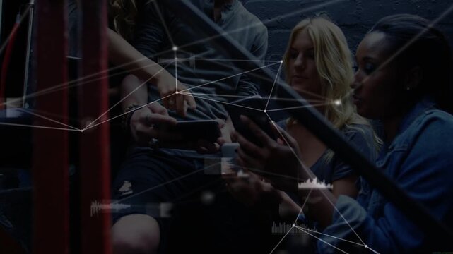 Four adults clustering stairs, one holding phone up and passing devices, tech HUD sharing content