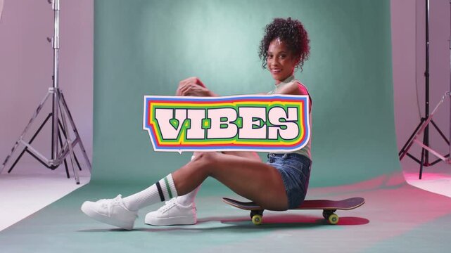 Woman posing on skateboard in mint-green studio wearing denim shorts with VIBES overlay