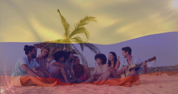 Chatting 8 friends lounging on blanket by palm tree with lights, in summer wear, acoustic guitar