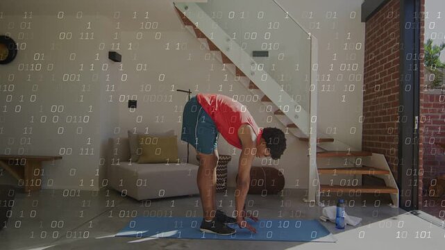 Man starting warm-up by hinging forward, lowering torso, placing palms on blue mat for fitness