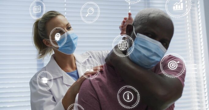 Examining clinician checking patient's neck in exam with lab coat, masks, maroon tee, digital icons