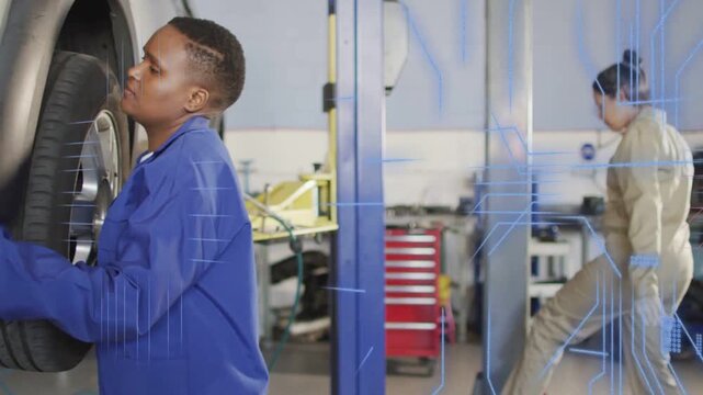Lift rising as blue tech removing tire, inspecting wheel for service, helper walking past chest