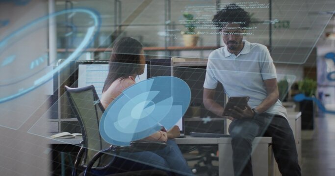 Reviewing code in office, team casually dressed holding tablet at dual monitors with digital UI