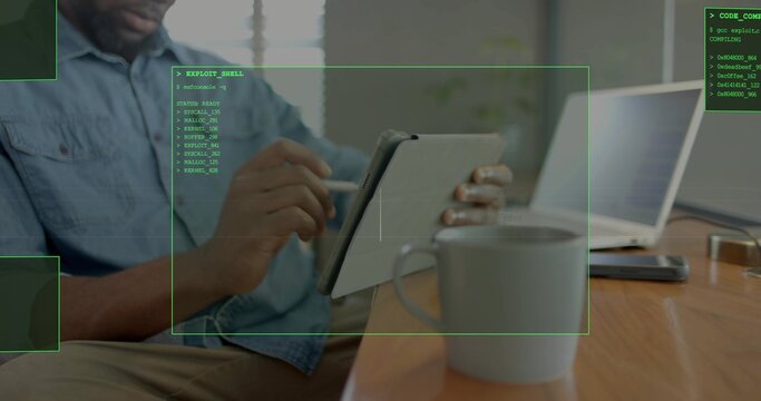 Using tablet with stylus, denim-shirted man working in home office with laptop and green overlays