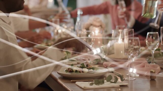 Guests passing bottle and pouring wine at wedding table, light streaks enhancing celebratory toast