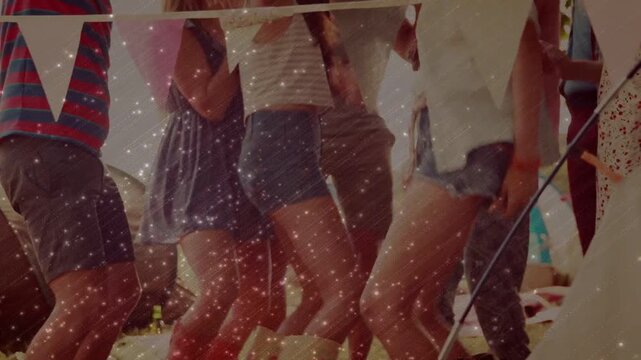 Group dancing under bunting in festival tent, music starting, confetti overlay matching rhythm