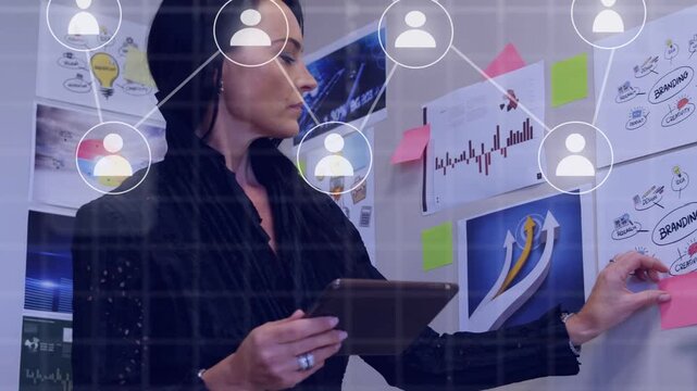 Woman manager tapping tablet and moving sticky notes, creating business network map linking charts