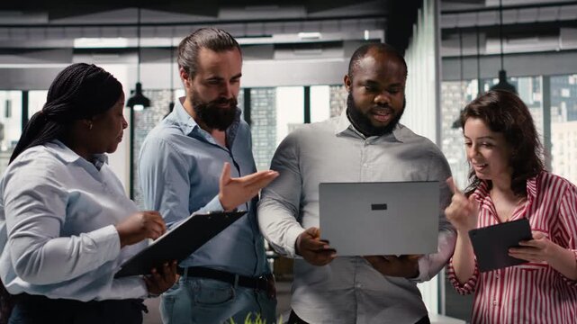 Multiethnic group of colleagues working on marketing strategy with reports, sharing ideas and insights for business management and administration. Diverse people making decisions.
