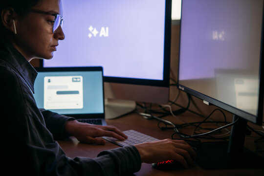Young woman writing AI promt in a modern office.