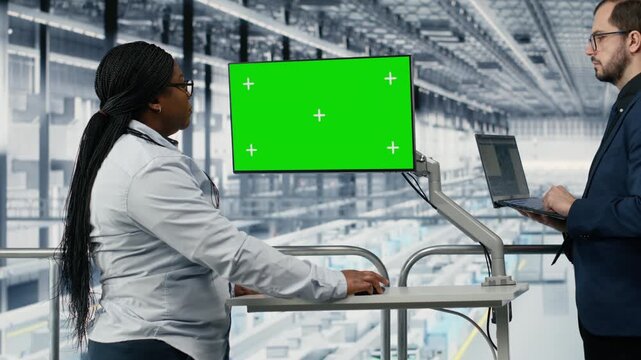 Isolated screen monitor used by colleagues monitoring industry 4.0 microelectronics manufacturing plant workflow. Coworkers use chroma key display to track smart factory microchip production, camera B