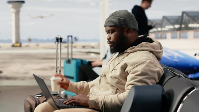 Digital nomad stretching muscles of lower back and neck near the gate, waiting for international flight. Flexible remote online work with global mobility and virtual office in airport terminal.