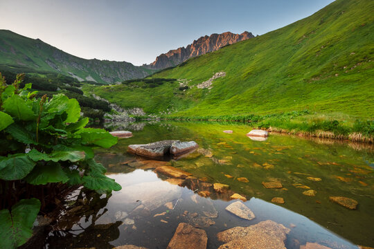 View of Bystre pleso lake with clear water and rocky peaks in the Low Tatras National Park, Liptovsky Mikulas, Zilinsky kraj, Slovakia.