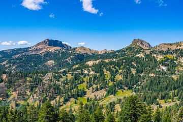 Scenic vista of rugged mountain peaks and dense coniferous forests stretching across the volcanic landscape of the Sierra Nevada. © ZL Visuals