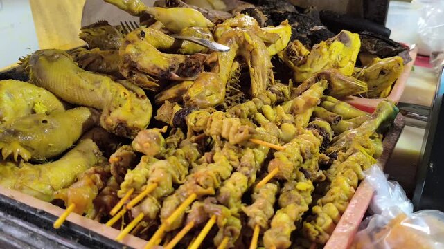 Assorted Yellow Spiced Chicken Giblets, Intestines, and Heads on Display
