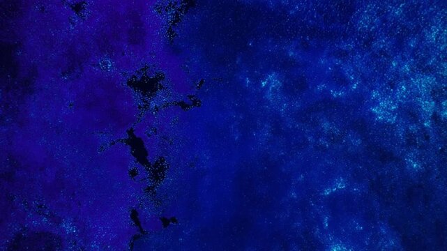 真上から見下ろす生物発光プランクトンの湾・宇宙的な青紫色の光のパターン
