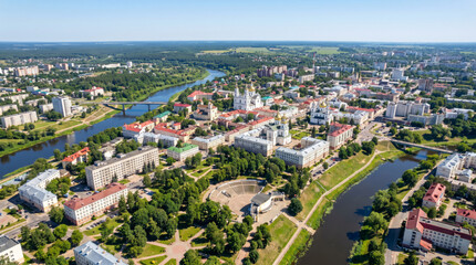 Fototapeta premium Aerial view of a European city with a river flowing through it and green parks.