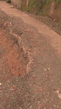 Landslide on road edge with falling dirt natural disaster damage scene
