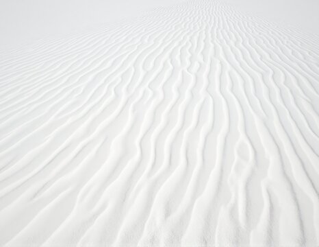 White sands in Death Valley, rippled dunes under clear blue sky, distant mountains, stark desert landscape