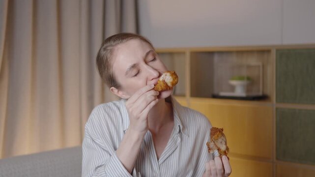 Slow motion video capturing woman's pure gastronomic bliss while savoring crispy fried chicken, expressing deep culinary pleasure through facial expressions and enjoyment