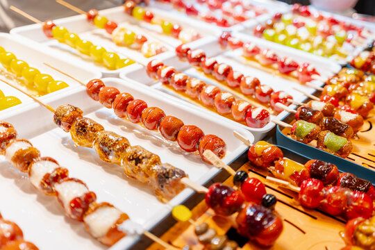 Traditional Chinese candied fruit snacks, known as Tanghulu at street food market.