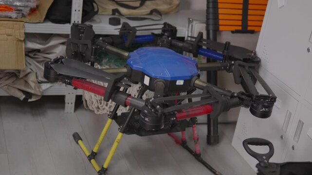 Large hexacopter drone standing on gray floor, representing advanced engineering, autonomous flight, and the future of remote controlled surveillance, delivery, and inspection services