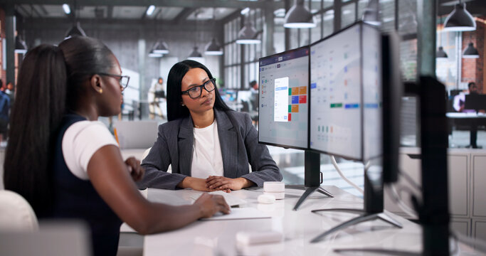 Human Resource Manager Explains Payroll Software To Two Women Colleagues