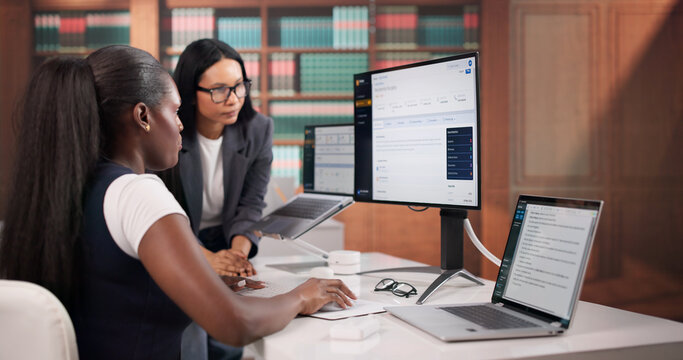 Lawyer Carefully Reviewing Contract Documents On Laptop
