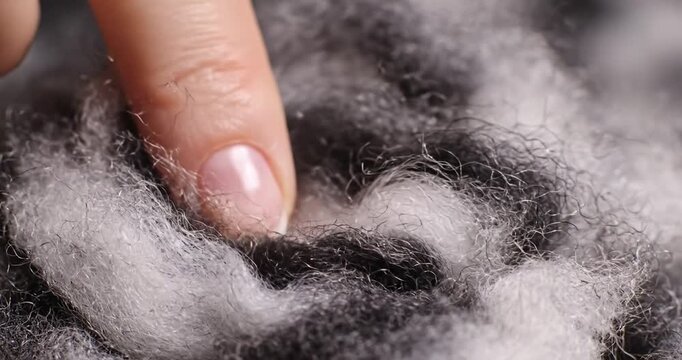 Hand touching soft black fabric texture.